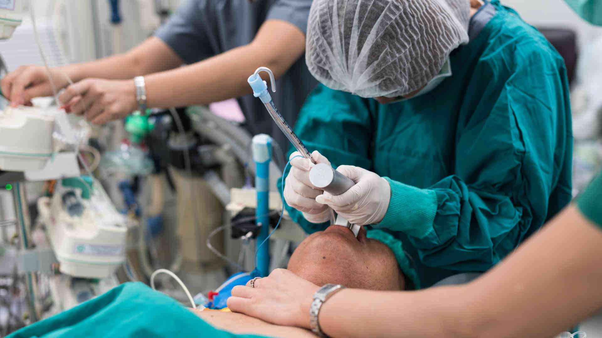 Anaesthetist intubating patient in theatre