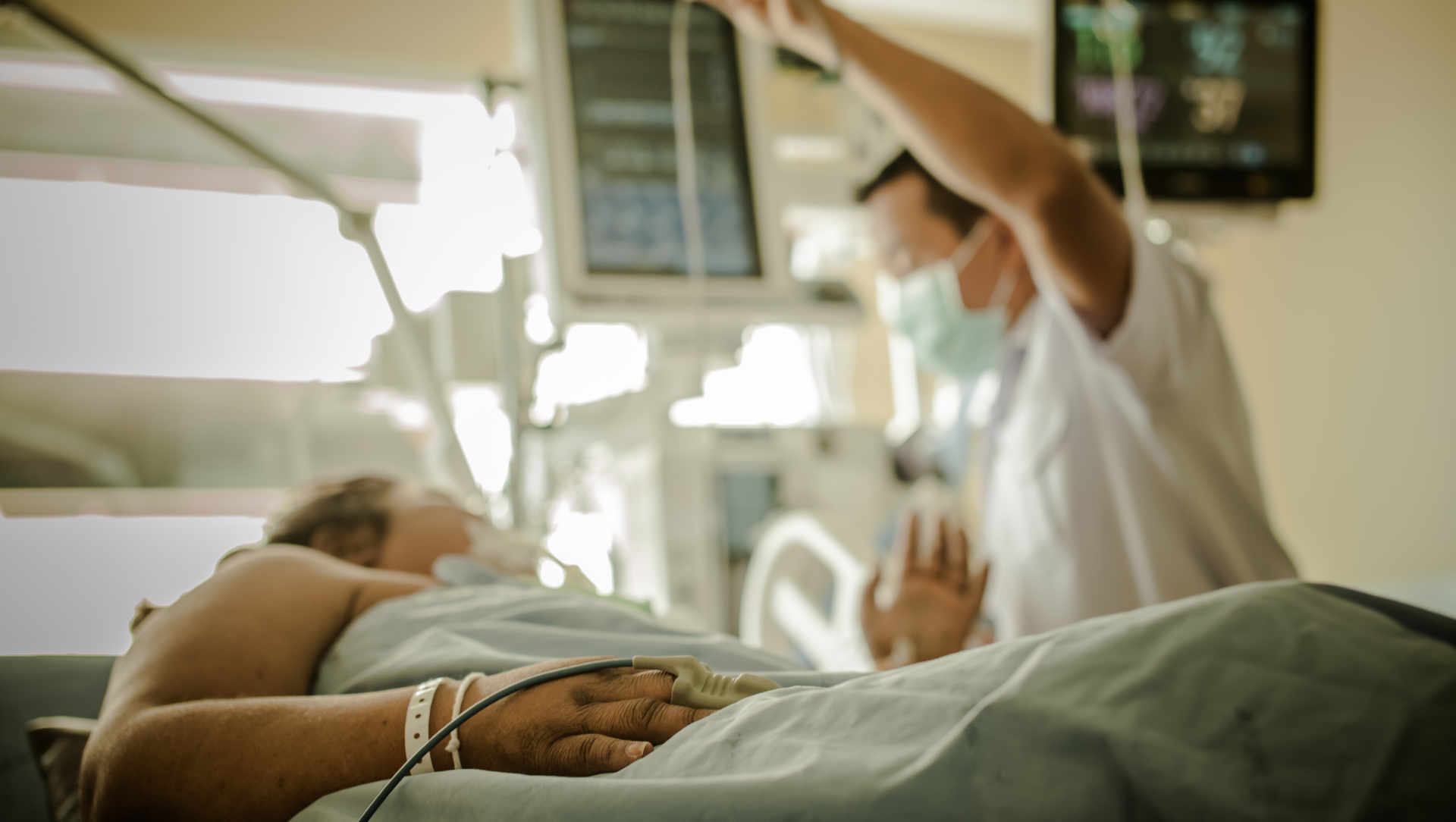 ICU patient in bed with nurse standing beside