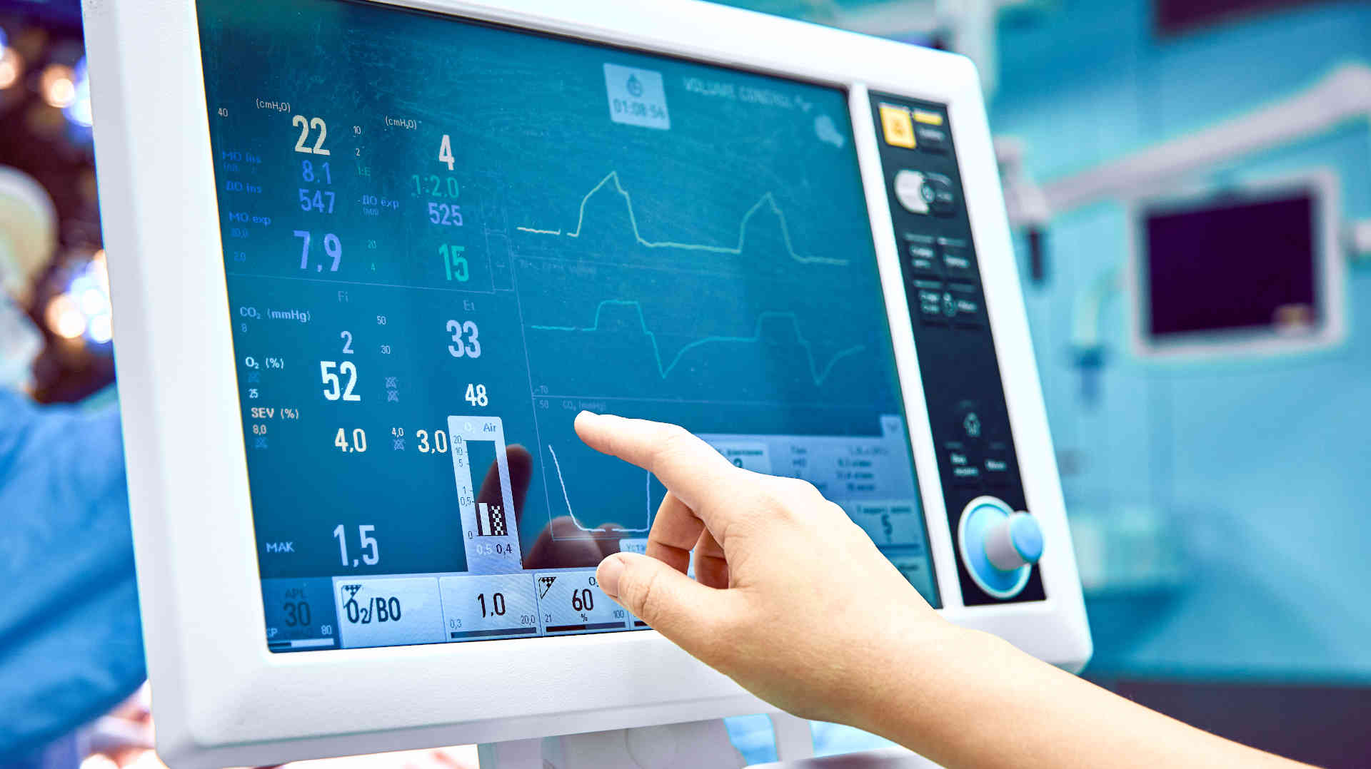 Doctor changing settings on a mechanical ventilator