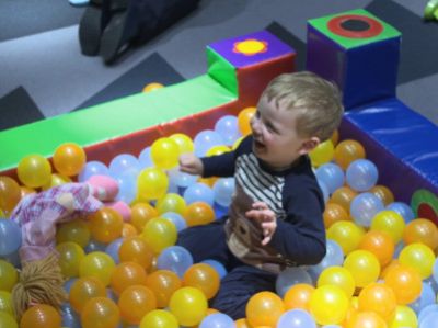 Child in soft play area with small plastic ball pool
